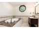 Soaking tub with marble detail and a circular window providing ample light at 3884 Vic Ar Ct, Peachtree Corners, GA 30360
