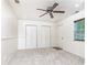 Carpeted bedroom with two closets, a ceiling fan, a window, and a neutral color scheme at 3884 Vic Ar Ct, Peachtree Corners, GA 30360