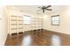 This bedroom has hardwood floors, ceiling fan, two windows, and white shelving units at 3884 Vic Ar Ct, Peachtree Corners, GA 30360