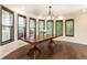 Bright dining room with a large wooden table, dark hardwood floors, and natural light from several windows at 3884 Vic Ar Ct, Peachtree Corners, GA 30360