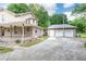 Home featuring brick accents, a two-car garage, and an expansive driveway, complemented by an inviting covered porch at 3884 Vic Ar Ct, Peachtree Corners, GA 30360