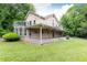 Exterior view of a two-story house with a wrap-around porch and upper deck overlooking a well-manicured lawn at 3884 Vic Ar Ct, Peachtree Corners, GA 30360
