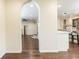 Hallway with an archway leading to a kitchen with bar seating and hardwood floors at 3884 Vic Ar Ct, Peachtree Corners, GA 30360