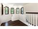 Upstairs hallway featuring dark hardwood flooring, white railings, and natural light streaming through several windows at 3884 Vic Ar Ct, Peachtree Corners, GA 30360