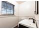 Charming powder room featuring a modern sink, stylish faucet, and a bright window with classic trim at 3884 Vic Ar Ct, Peachtree Corners, GA 30360