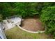 Aerial view shows a spacious backyard with a deck and stone border, surrounded by trees at 132 Picketts Creek Dr, Acworth, GA 30101