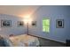 Serene bedroom with blue walls, sunny window, and artistic decor providing a cozy retreat at 132 Picketts Creek Dr, Acworth, GA 30101