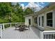 Outdoor deck features a dining set, decorative string lights, and wooded views at 132 Picketts Creek Dr, Acworth, GA 30101