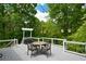 Outdoor deck features a dining set, decorative string lights, and serene wooded views at 132 Picketts Creek Dr, Acworth, GA 30101