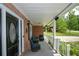 Relaxing covered front porch with seating area, ceiling fan, and view of the landscaped yard at 132 Picketts Creek Dr, Acworth, GA 30101