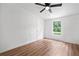 This bedroom features wood floors, a ceiling fan, and a window view at 170 White Rose Ln, Temple, GA 30179