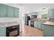 Kitchen features green cabinets, black appliances and wood-look floors at 170 White Rose Ln, Temple, GA 30179