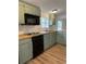 Close-up of kitchen featuring muted green cabinets, modern appliances, and wooden countertops at 170 White Rose Ln, Temple, GA 30179