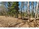 Natural wooded setting surrounds the home with mature trees, underbrush, and fallen leaves at 2488 Fontainebleau Dr, Dunwoody, GA 30360