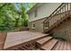 The home features a large wooden backyard deck overlooking a wooded yard with stairs leading to the upper level at 2488 Fontainebleau Dr, Dunwoody, GA 30360