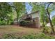 Exterior view of the home featuring a deck, brick facade, and mature trees at 2488 Fontainebleau Dr, Dunwoody, GA 30360