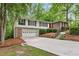 Lovely exterior view of home with driveway, red front door, brick facade, and lush, mature landscaping at 2488 Fontainebleau Dr, Dunwoody, GA 30360