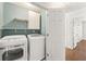 Convenient laundry room with washer, dryer, storage shelves, and easy access to the hallway at 2488 Fontainebleau Dr, Dunwoody, GA 30360