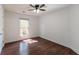 White bedroom with a ceiling fan, hardwood floors, and natural light from window at 1287 Peninsula Trce, Lawrenceville, GA 30044