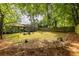 Large backyard with mature trees offers ample space for outdoor activities and relaxation, with a fire pit and deck at 1875 Fairway Ne Cir, Atlanta, GA 30319