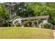Charming single-story home featuring a well-manicured lawn, carport, and mature trees at 1875 Fairway Ne Cir, Atlanta, GA 30319