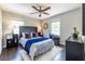 Comfortable bedroom with a ceiling fan, two windows, hardwood flooring, and a tufted headboard at 1875 Fairway Ne Cir, Atlanta, GA 30319