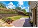 Landscaped backyard featuring a stone patio, lush lawn, terraced retaining wall, and stairs leading up the hill at 2022 Boxwood Ln, Canton, GA 30114