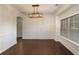 Modern dining room featuring wainscoting, an elegant chandelier, and dark hardwood flooring at 2022 Boxwood Ln, Canton, GA 30114