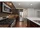 Gourmet kitchen with granite counters, stainless steel appliances, and dark wood cabinets at 2022 Boxwood Ln, Canton, GA 30114