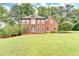 Charming brick two-story home with well-manicured lawn and mature trees on a sunny day at 3160 Bailey Cove Ct, Dacula, GA 30019