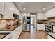 Bright kitchen showcasing stainless steel refrigerator and accents, granite countertops, and hardwood floors at 3160 Bailey Cove Ct, Dacula, GA 30019