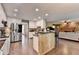 Open kitchen featuring white cabinets, stainless steel appliances, and seamless flow into living room at 3160 Bailey Cove Ct, Dacula, GA 30019