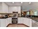 Updated kitchen features white cabinetry, stainless steel appliances, and granite countertops at 3160 Bailey Cove Ct, Dacula, GA 30019