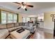 Open living room with hardwood floors and gray sectional overlooking the kitchen at 3160 Bailey Cove Ct, Dacula, GA 30019