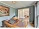 Comfortable office space with wooden desk, light blue walls, and view into another room at 3160 Bailey Cove Ct, Dacula, GA 30019