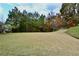 Expansive backyard with a verdant lawn bordered by mature trees and foliage, offering a private outdoor setting at 5635 Cedar Pass, Fairburn, GA 30213