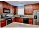 Well-equipped kitchen with modern appliances, stone backsplash, and dark wood cabinetry at 5635 Cedar Pass, Fairburn, GA 30213