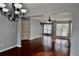 Open-concept living room with hardwood floors and a decorative chandelier at 5635 Cedar Pass, Fairburn, GA 30213