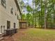 Spacious backyard with a wooden deck and a lush green lawn surrounded by mature trees at 7155 Homestead Rd, Rex, GA 30273