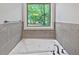 Bathroom soaking tub with tile surround and natural light at 7155 Homestead Rd, Rex, GA 30273