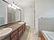 Bright bathroom featuring a double sink vanity, large mirror, shower and soaking tub at 7155 Homestead Rd, Rex, GA 30273