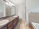 Bathroom featuring double sinks, large mirror, walk-in shower, and separate tub at 7155 Homestead Rd, Rex, GA 30273