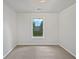Bedroom with neutral carpet, white walls, and a window providing natural light at 7155 Homestead Rd, Rex, GA 30273