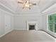 Carpeted primary bedroom with fireplace, neutral colors, tray ceiling and natural light at 7155 Homestead Rd, Rex, GA 30273