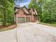 Beautiful two-story brick home with a spacious driveway and a two car garage surrounded by mature trees at 7155 Homestead Rd, Rex, GA 30273