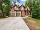 Beautiful two-story brick home with a spacious driveway and a two car garage surrounded by mature trees at 7155 Homestead Rd, Rex, GA 30273