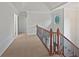 Hallway with wood and wrought iron railing, carpet and natural light from large windows at 7155 Homestead Rd, Rex, GA 30273