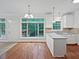 Open kitchen with white cabinets, granite countertops, stainless steel sink and hardwood floors at 7155 Homestead Rd, Rex, GA 30273