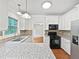 Bright kitchen with white cabinetry, granite countertops, stainless steel appliances and hardwood floors at 7155 Homestead Rd, Rex, GA 30273