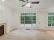 Living room with carpet, fireplace, windows with a view of mature trees, and a white door leading to a deck at 7155 Homestead Rd, Rex, GA 30273